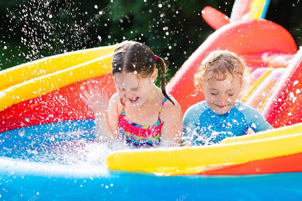 copii care se joaca in piscina gonflabila in apa danduse pe topogan